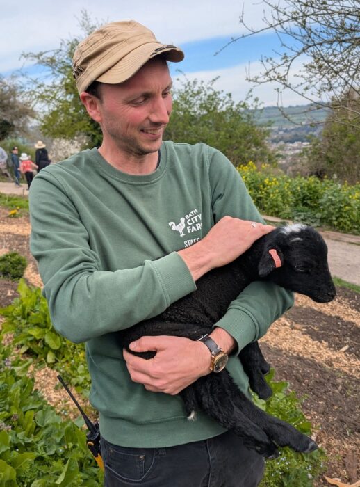 Bath city farm volunteer with lamb